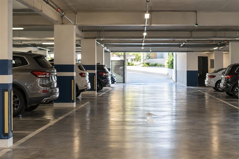 Veículos organizados nas vagas de uma garagem condominial.